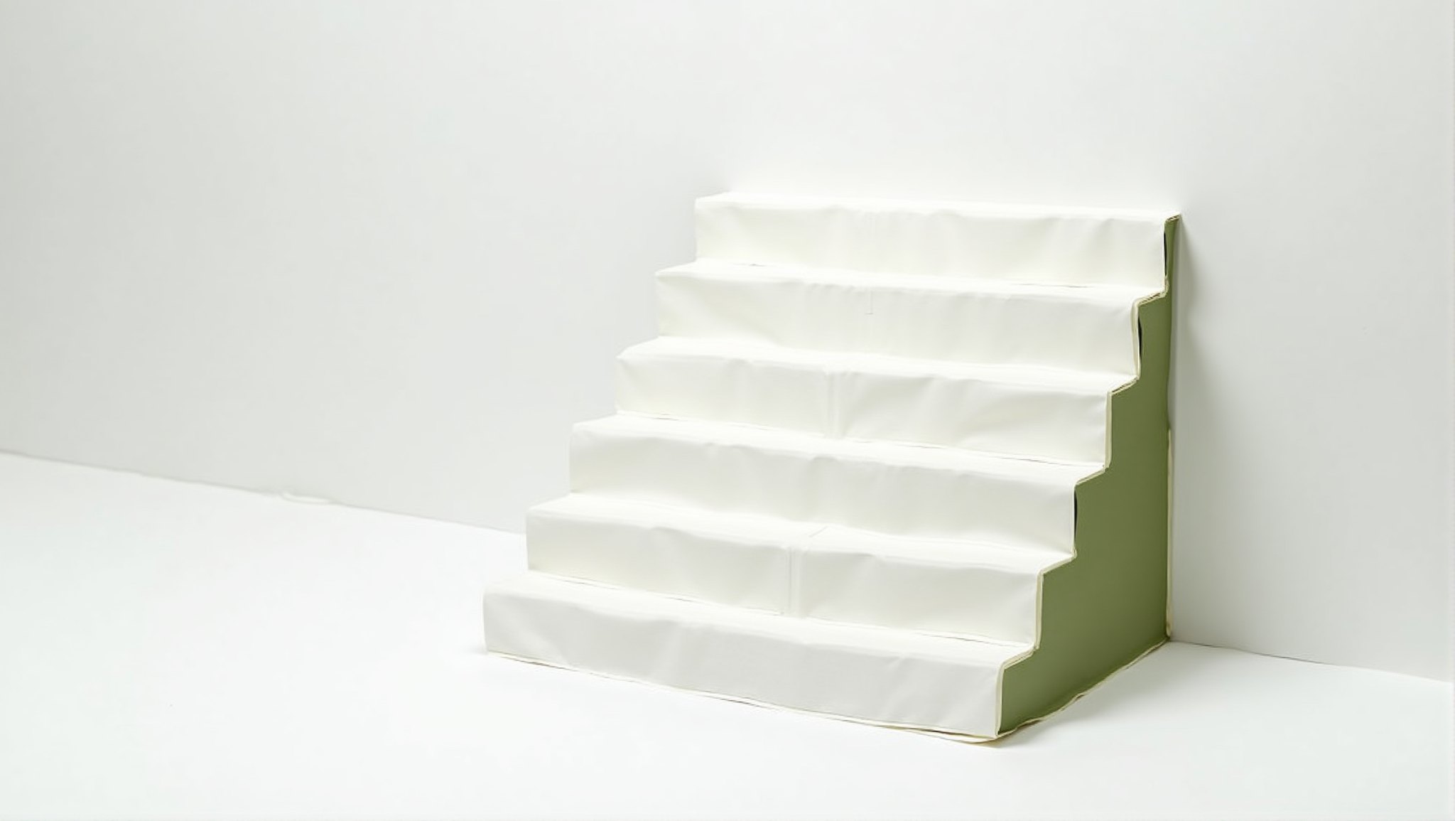 Six steps folded from white paper with one matte olive-green end face, on a white surface
